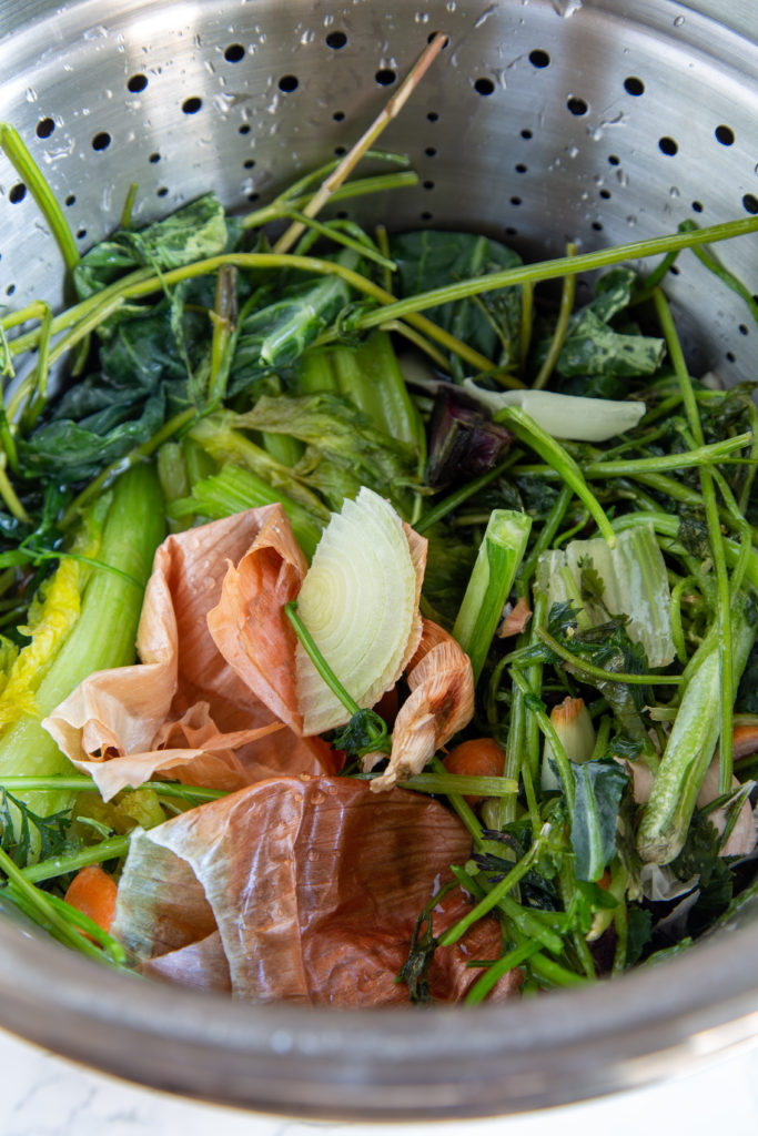 Vegetable scraps in pasta strainer